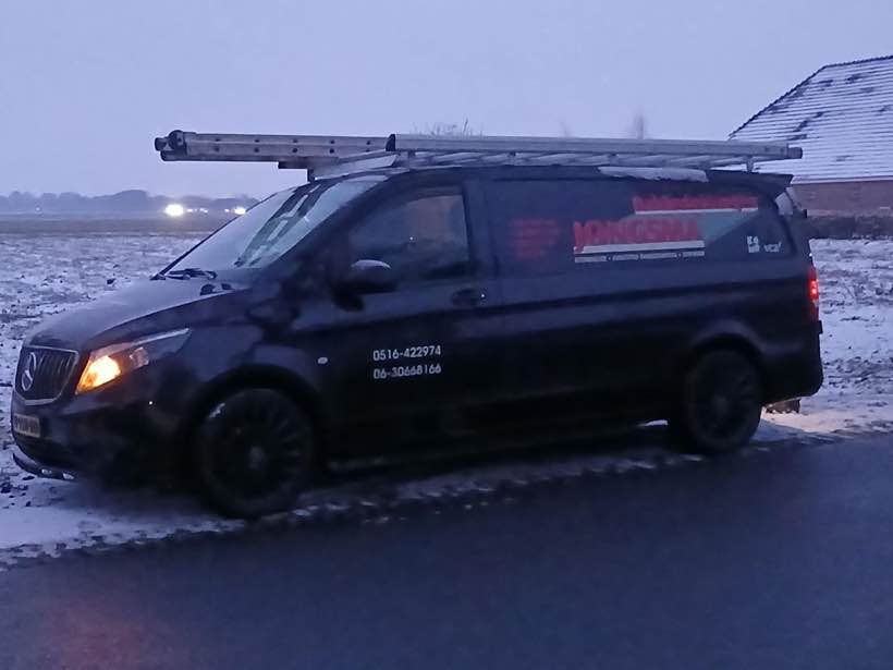 Zwarte bus van Jongsma Dakbedekkingen in de sneeuw