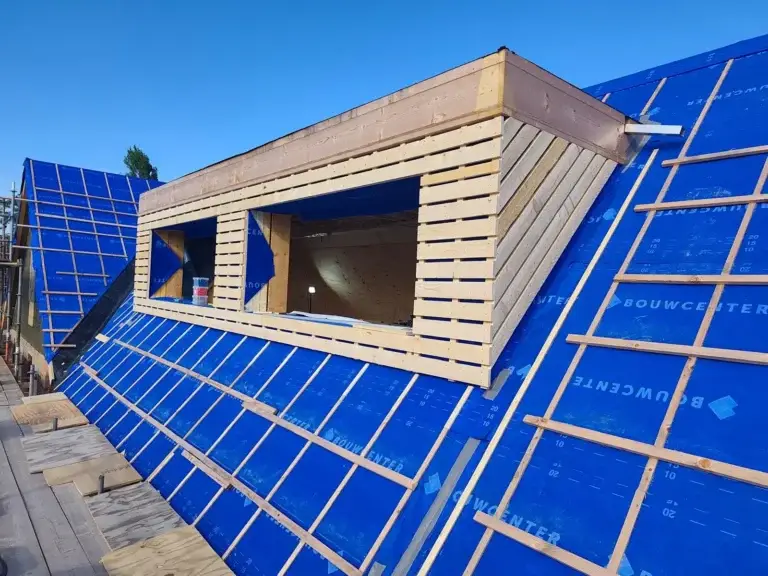 Houtwerk van een nieuwe dakkapel op een pannendak