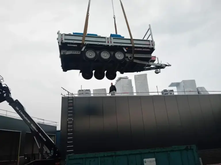 Materiaal wordt met een kraan op het dak gehesen